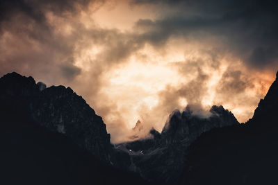 Low angle view of silhouette mountains against dramatic sky