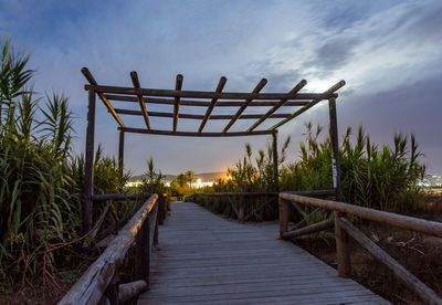 Footbridge over sea against sky