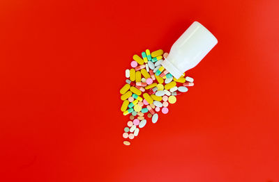 High angle view of multi colored pencils against red background