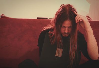 Man with long hair sitting at home