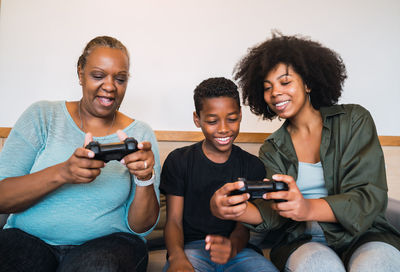 Happy multi-generation family playing video game at home