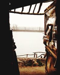 Metal railing by sea against sky