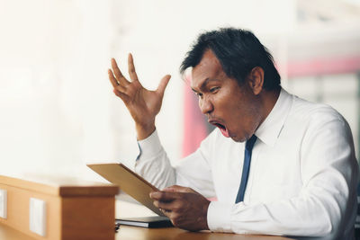 View of frustrated man sitting in office