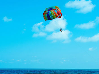 People paragliding over sea against sky