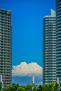 Low angle view of modern buildings against clear blue sky