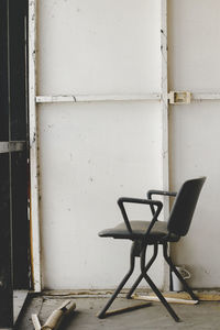 Empty chair on table against wall in old building