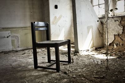 Empty chairs and table in abandoned building