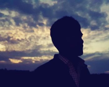 Close-up of silhouette boy against sky during sunset