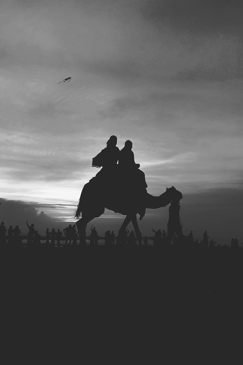 SILHOUETTE PEOPLE ON BEACH AGAINST SKY AT SUNSET