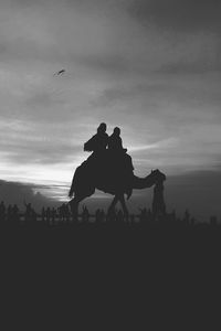 Silhouette people against sky during sunset