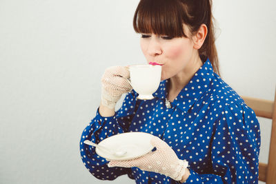 Young woman holding coffee cup over white background