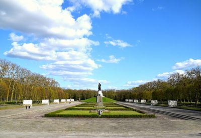 View of sculpture in formal garden against cloudy sky