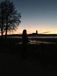 Silhouette woman looking at sunset