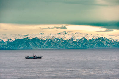 Scenic view of lake baikal and snowcapped mountains against sky