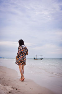 Rear view of woman standing on beach