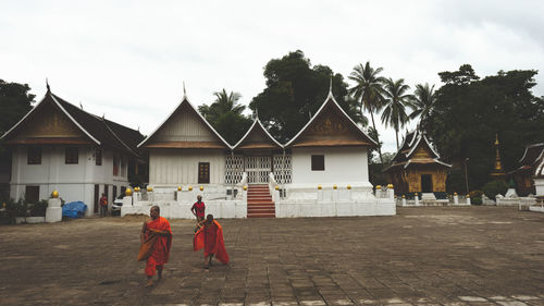 Rear view of boy walking in temple against sky