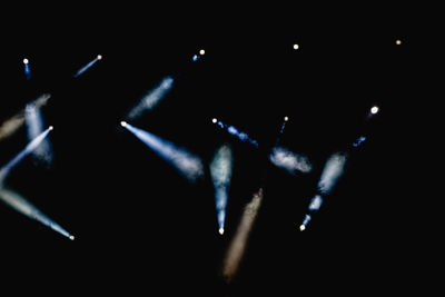 Close-up of illuminated lighting equipment against black background