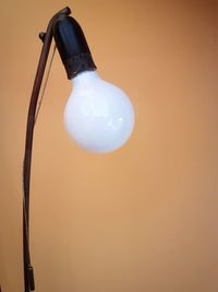 Close-up of light bulb against beige wall