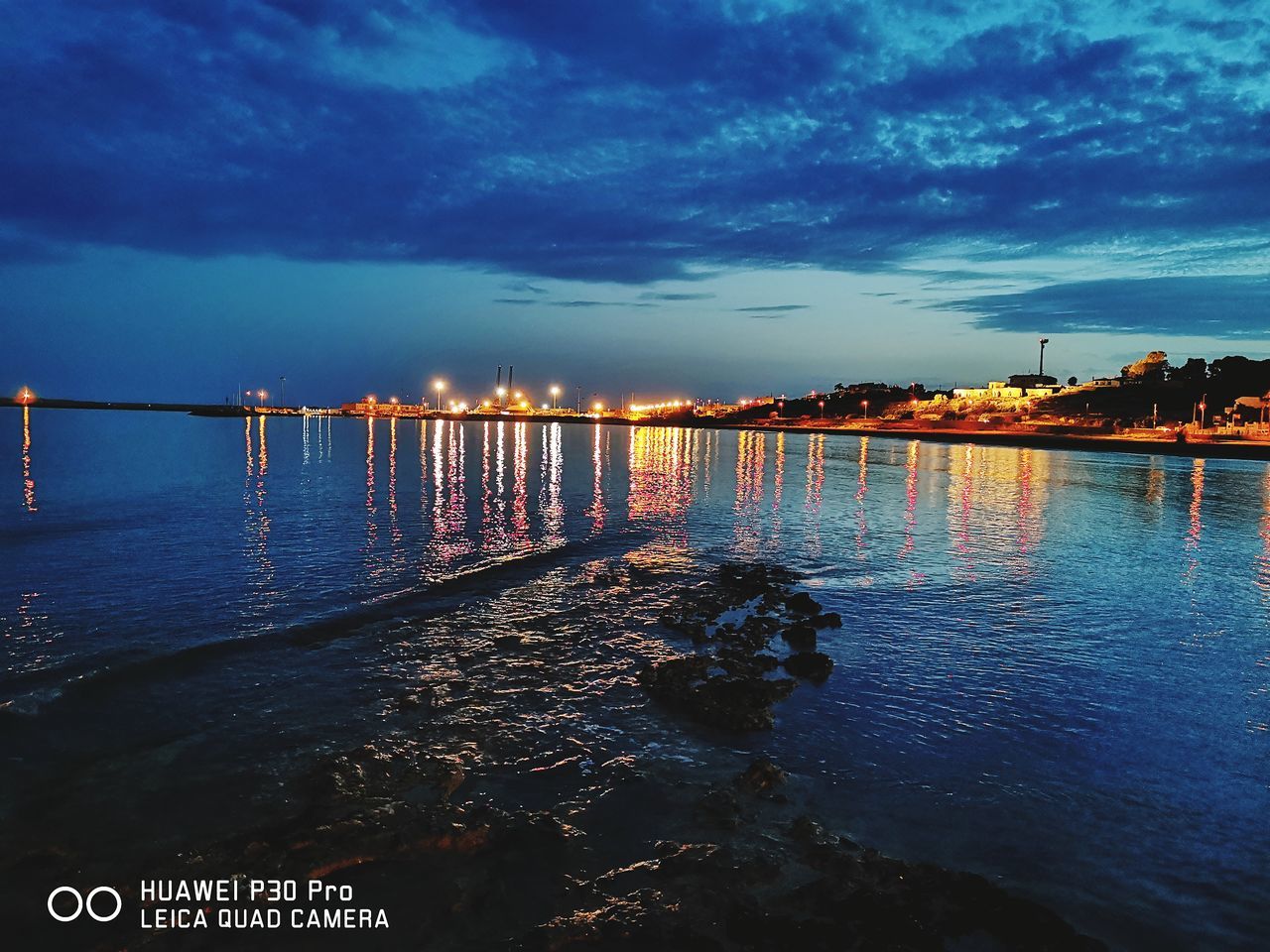 water, sky, reflection, dusk, horizon, sea, cloud, architecture, evening, nature, built structure, sunset, ocean, night, pier, travel destinations, city, beach, scenics - nature, beauty in nature, land, no people, coast, outdoors, building exterior, travel, blue, shore, transportation, tranquility, bridge, landscape, environment, illuminated, tourism, wave, bay, building, tranquil scene, nautical vessel