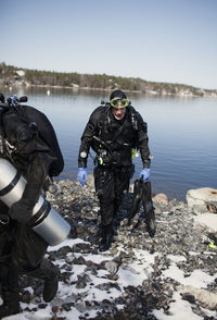 Two divers walking out of water