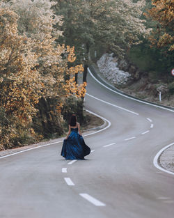 Rear view of woman walking on road