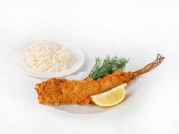 Close-up of food served in plate against white background