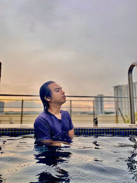 Man looking at swimming pool against sky