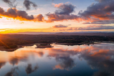 Drone aerial view of a lake reservoir of a dam with reflection on the water in sabugal, portugal