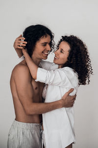 Happy heterosexual couple man and woman embracing white background