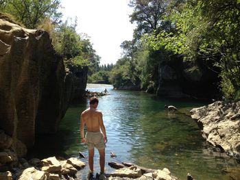 Man standing on rock by river