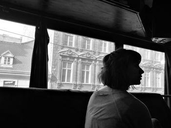 Rear view of woman looking away while sitting in van