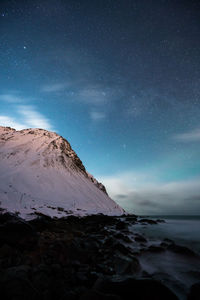 Scenic view of snowcapped mountains against sky at night