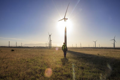 Engineer walking on a wind farm at sunset