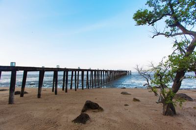 View of pier on beach against sky