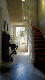 Grand piano by staircase at abandoned home