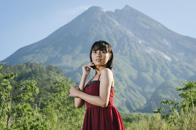 Full length of woman standing on rocks against mountain