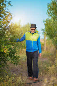 Full length of young man standing against trees