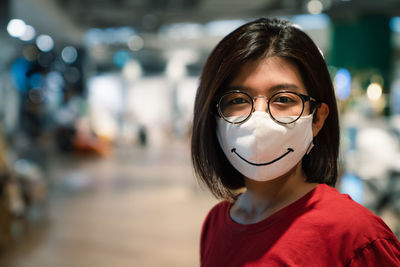 Close-up portrait of young woman wearing mask standing at mall