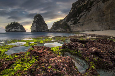 Rocks on sea shore against sky