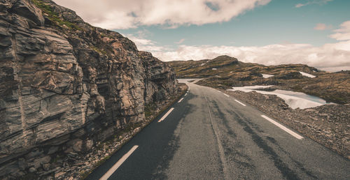 Road amidst rocks against sky