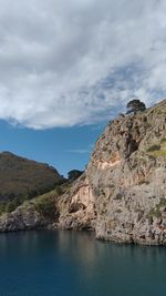Rock formations by sea against sky