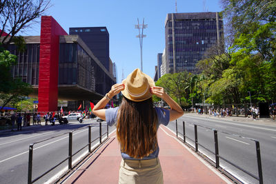 Rear view of woman standing against building