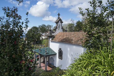 Statue amidst trees and building against sky