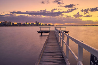 Pier on sea at sunset