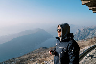 Rear view of man standing against mountain