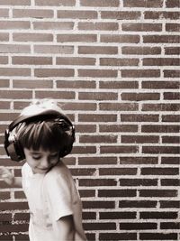 Girl standing on brick wall