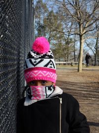 Portrait of boy with pink umbrella against trees