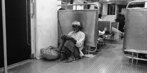 Mature man sitting on diamond plate in train