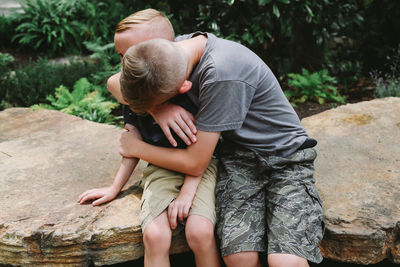 Rear view of couple holding hands on tree