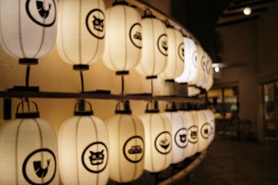 Close-up of illuminated lanterns hanging on wall in building